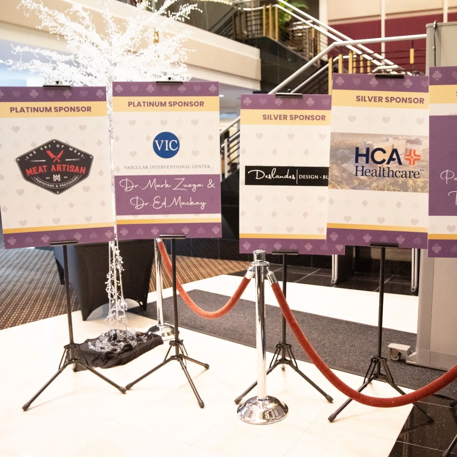 Sponsor signs on easels at the entrance, naming platinum and silver sponsors