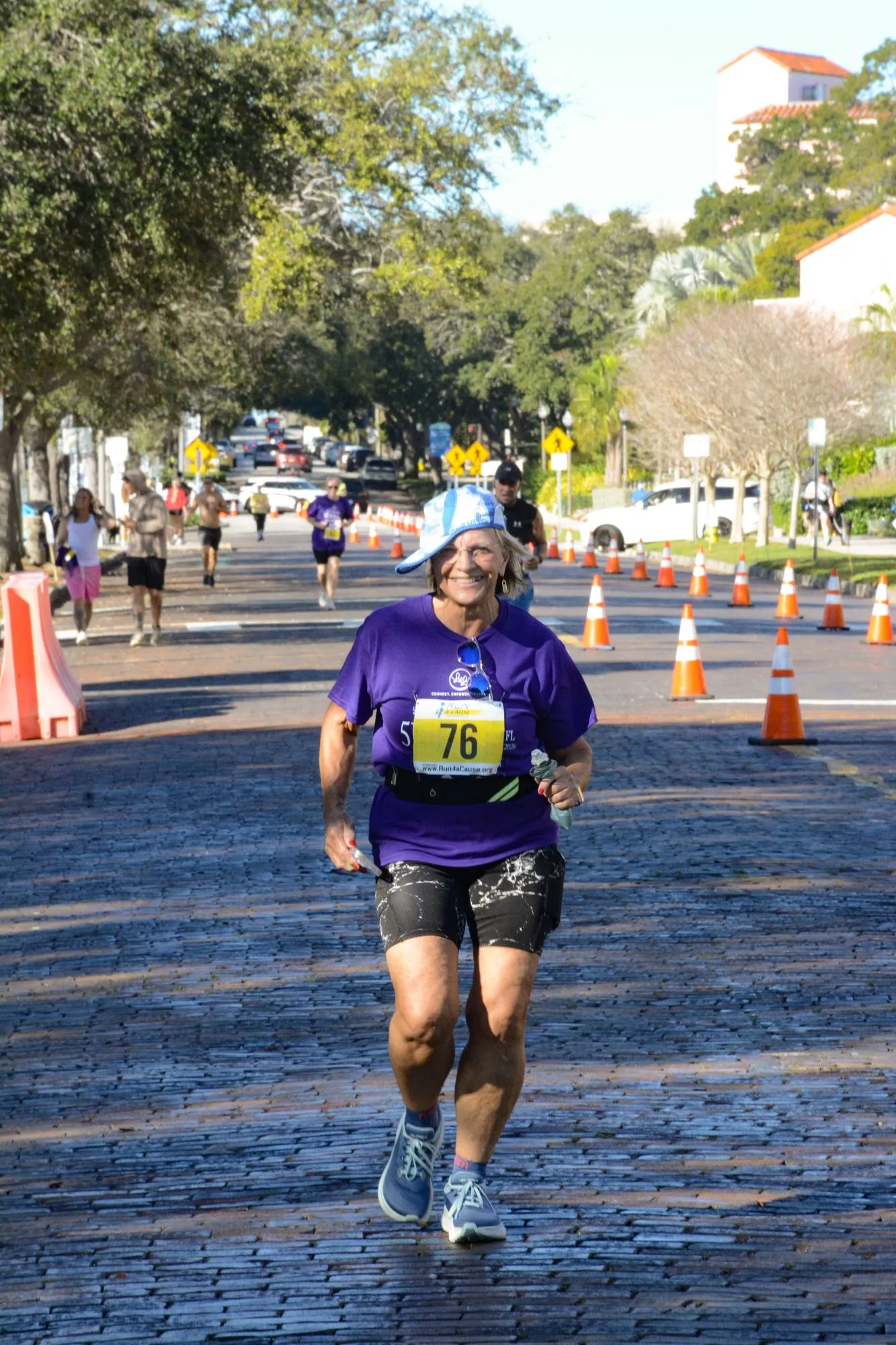 A runner in a purple Laurie’s Love shirt on the cone-lined 2026 course