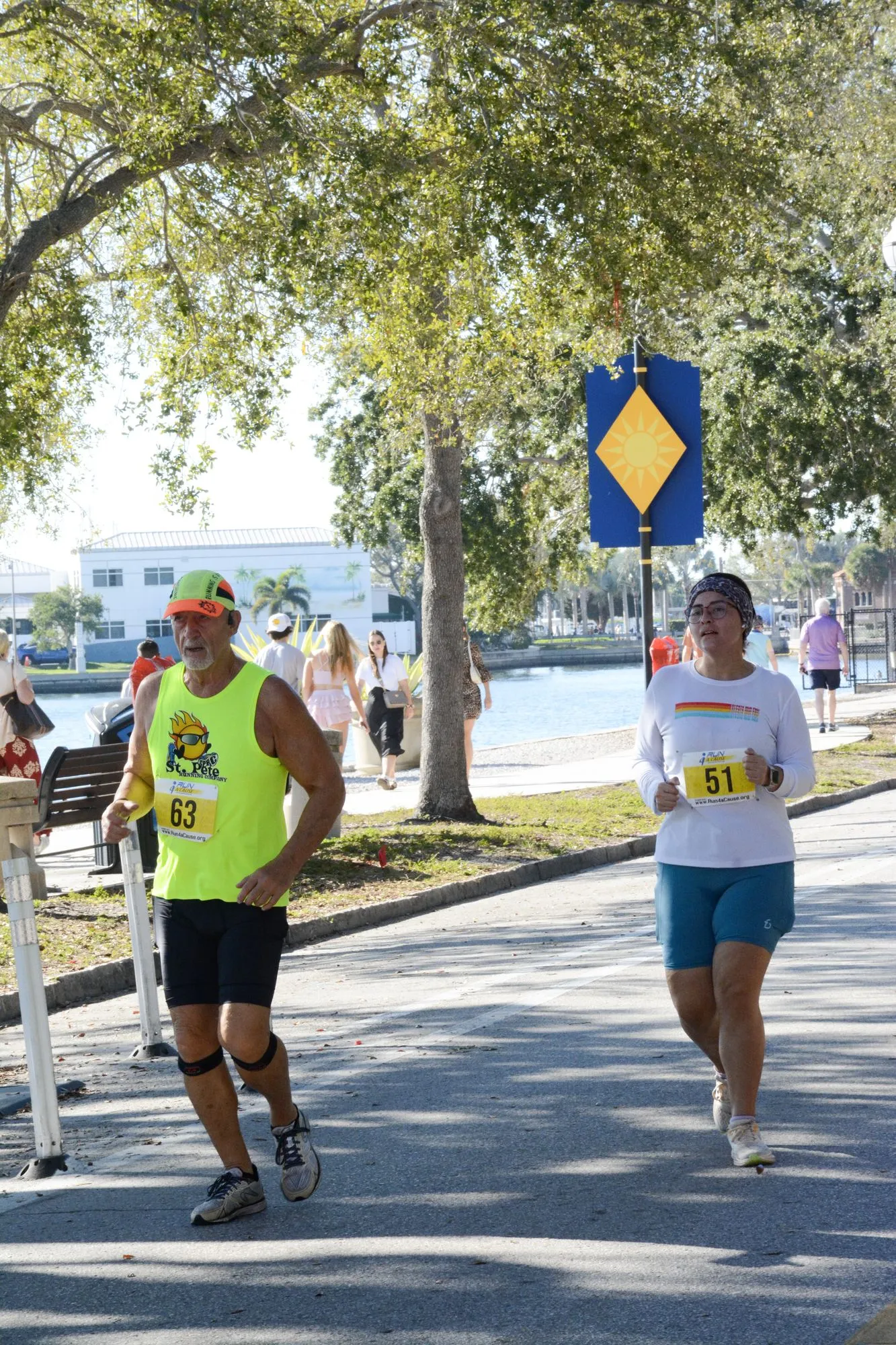 Two runners with race bibs on a tree-lined road during the 2026 Laurie’s Love Legacy Run