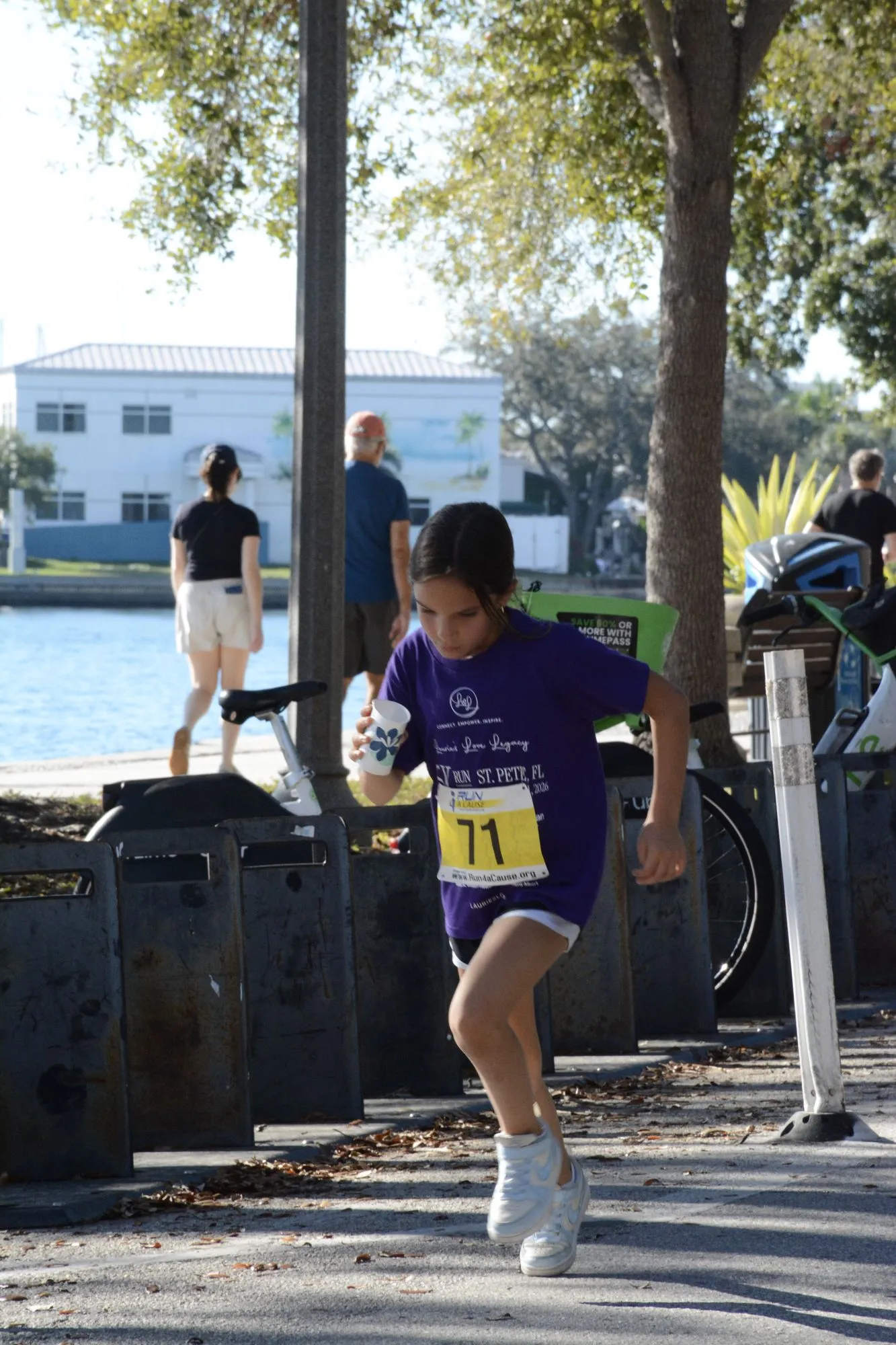 A young runner in a purple shirt on the 2026 course near the water